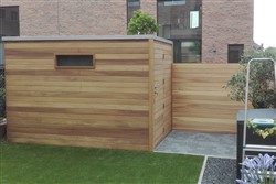 Tuinhuis met plat dak en houten hek